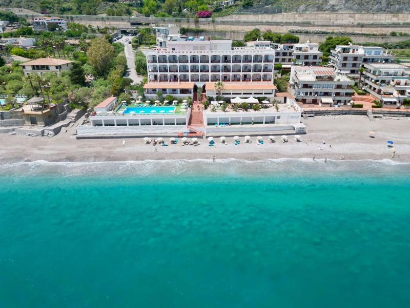 Widok na hotel z basenami na piaszczystej plaży i turkusowym morzu