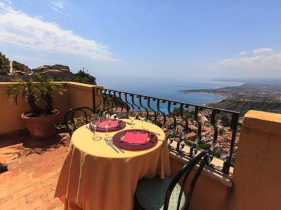 Terrasse mit gedecktem Tisch und Blick auf das Meer und die Küste