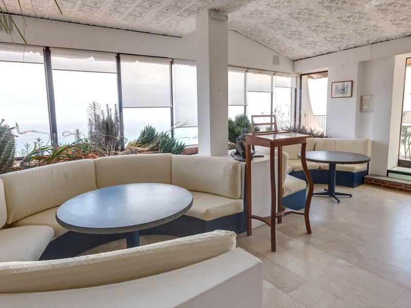 Modern lounge area with seating corners and large windows overlooking the sea.