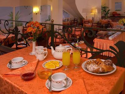 Cozy breakfast table with coffee, juice, and pastries in a welcoming restaurant.