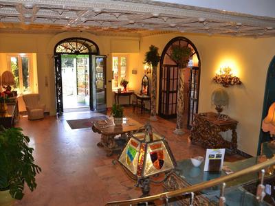 Inviting hotel lobby area with colorful lamps, antique furniture, and open entrance door.