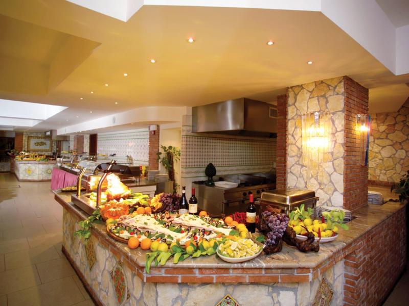 Buffet met diverse fruit- en groentesoorten in een warm verlichte hotel eetruimte.