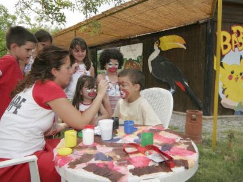 Modern hotel restaurant with teal bench seating, black chairs, and a wall mural of a woman's face.