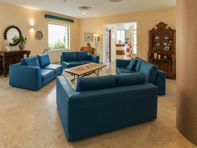 Gezellig hotel-loungedeel met blauwe banken, houten meubels en warm licht.