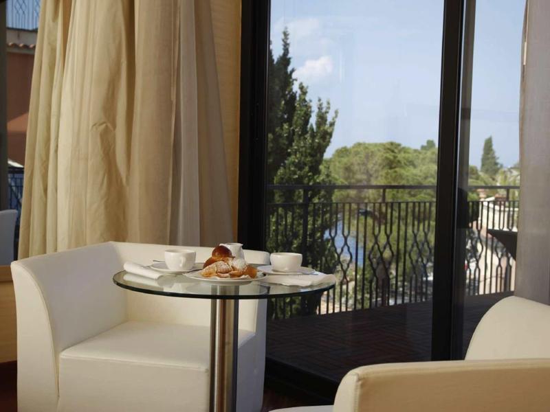 Gezellige zithoek met tafel, snacks en uitzicht op balkon en groen landschap.