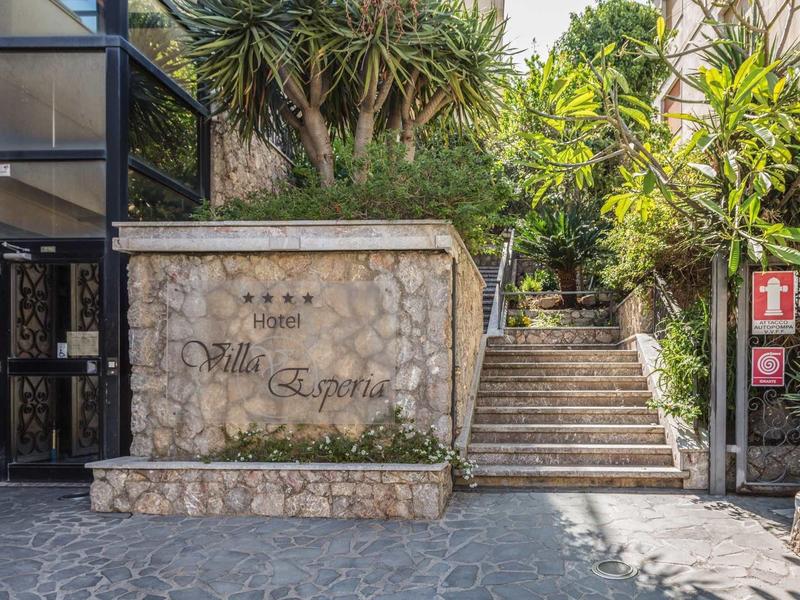 Ingang met stenen trap en bord voor Villa Esperia, omgeven door planten.