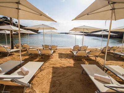 Chaises longues ensoleillées avec parasols au bord de la mer calme