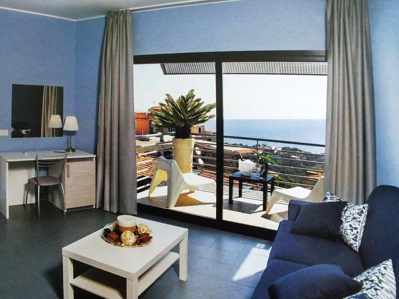 Lichte hotelkamer met blauwe muren, balkon en zeezicht