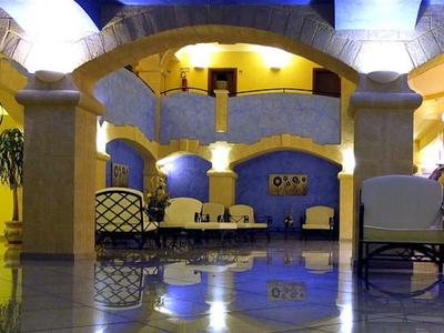 Bright, spacious hotel lobby area with arches, seating, and plants.