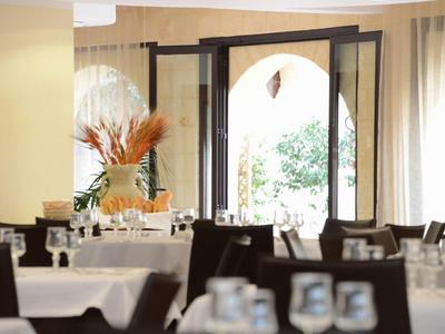 Bright dining room with set tables and an open door leading outside