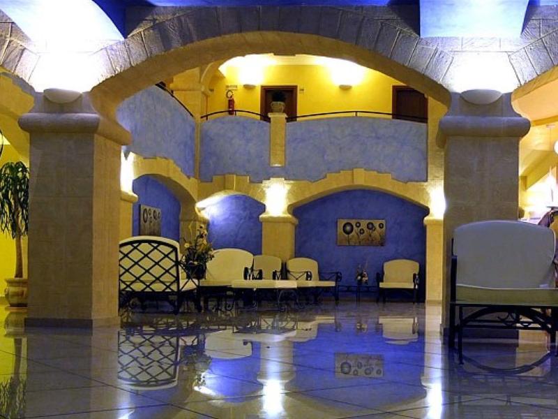 Bright, spacious hotel lobby area with arches, seating, and plants.