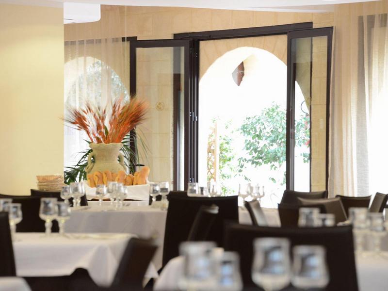 Bright dining room with set tables and an open door leading outside