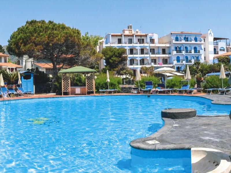 Grande piscina dell'hotel con sdraio e edificio su più piani sullo sfondo.