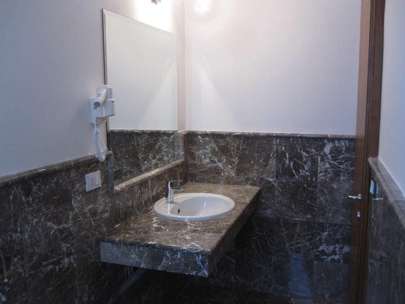 Salle de bain avec lavabo en marbre, miroir et éclairage de la coiffeuse.