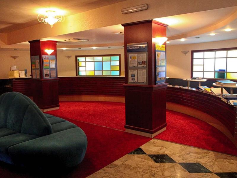 Intérieur d'un hall d'hôtel avec sièges élégants et fenêtre en verre coloré.