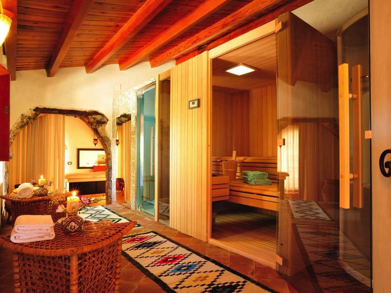 Pohodlná hotelová chodba s dřevěnými stěnami, kobercem a otevřenou wellness zónou se saunou