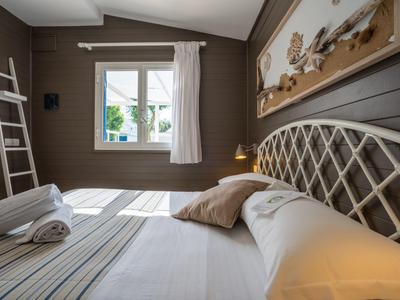 Camera d'albergo accogliente con letto, cuscini, asciugamani e finestra con vista esterna.