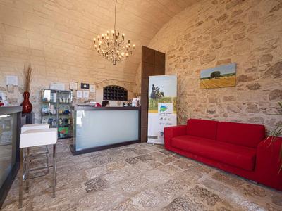 Heller Empfangsbereich mit Steinfassade, rotem Sofa und moderner Rezeption in einem Hotel