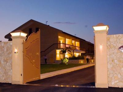 Porte d'entrée menant à un bâtiment d'hôtel éclairé au crépuscule avec des palmiers en arrière-plan