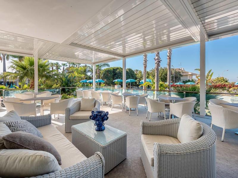 Otevřená terasa s pohodlným posezením a výhledem na tropickou zahradu.