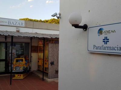 Zewnętrzna część parafarmacji z wejściem i znakami na ścianie pod niebieskim niebem