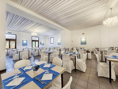 Elegancka jadalnia z białymi nakryciami stołów i niebieskimi akcentami w hotelu.