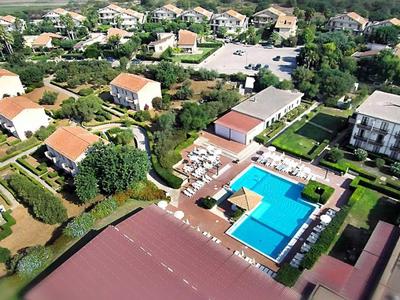 Widok z lotu ptaka na hotel z kilkoma budynkami i prostokątnym basenem w centrum.