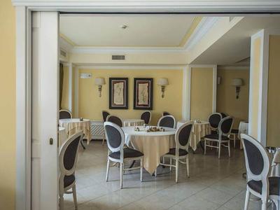 Elegant small dining room with round tables and gray chairs in a hotel.