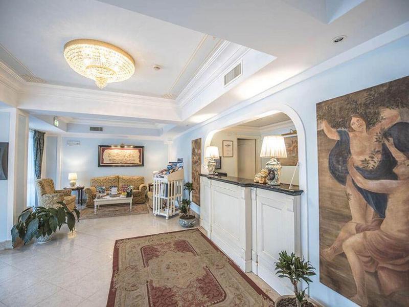 Espace lounge élégant d'hôtel avec des sièges confortables et des peintures décoratives aux murs.