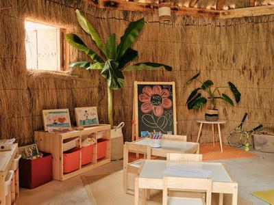 Příjemná místnost s hrázovými stěnami, malým oknem, rostlinami a dětským nábytkem s výtvarnými potřebami.