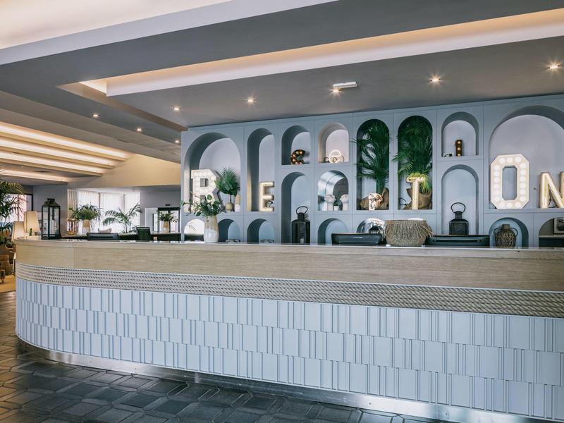 Hotelová recepce s velkými písmeny jako dekorací na zdi.