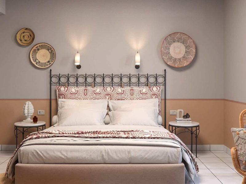 Pohodlný hotelový pokoj s pohodlnou manželskou postelí, nástěnnými dekoracemi a stylovými nočními stolky.