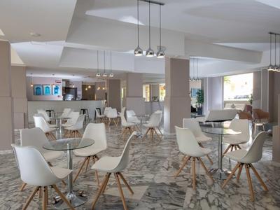 Nowoczesna przestrzeń śniadaniowa z białymi krzesłami i marmurową podłogą w jasnym pomieszczeniu.