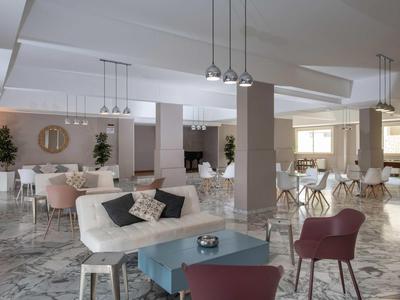 Jasna, nowoczesna przestrzeń hotelowa z wygodnymi miejscami do siedzenia i marmurową podłogą.