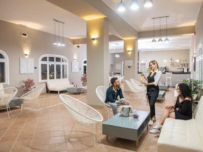 Helles Hotelfoyer mit modernen Möbeln und Gästen, die sich entspannen und unterhalten.