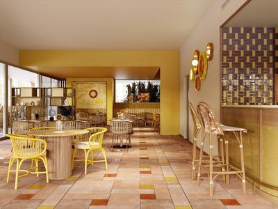 Moderní hotelová lounge s žlutými židlemi, mramorovými stoly a velkými okny.