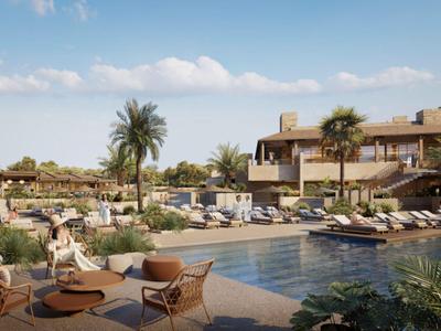 Luxusní hotelová bazénová oblast s lehátky, palmami a slunečníky za slunečného počasí.