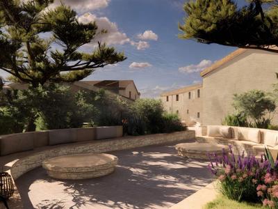 Kruhový posezení s kamennými stolky a lavicemi v zahradě pod stromy.