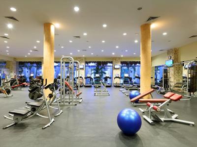 Großer, moderner Fitnessraum mit Geräten und blauem Gymnastikball