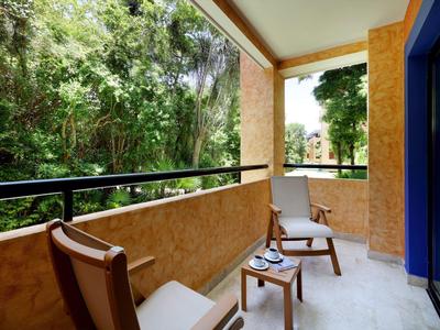 Balkon mit zwei Stühlen und einem kleinen Tisch mit Waldblick.