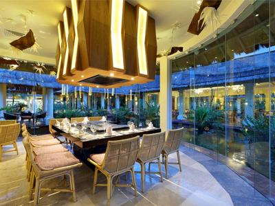 Modernes Restaurant mit großem Esstisch und Panoramafenstern in einem Hotel.