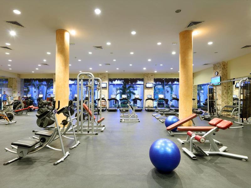 Geräumiger Fitnessraum mit Trainingsgeräten und großem blauen Gymnastikball.