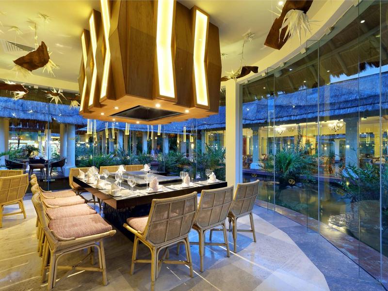 Modernes Restaurant mit großem Esstisch und Panoramafenstern in einem Hotel.