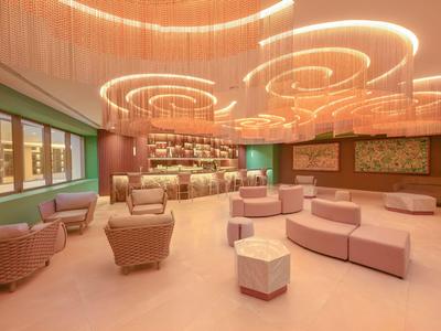 Ein modernes Hotel-Lounge mit runden Sitzgelegenheiten und hellen, warmen Deckenleuchten.