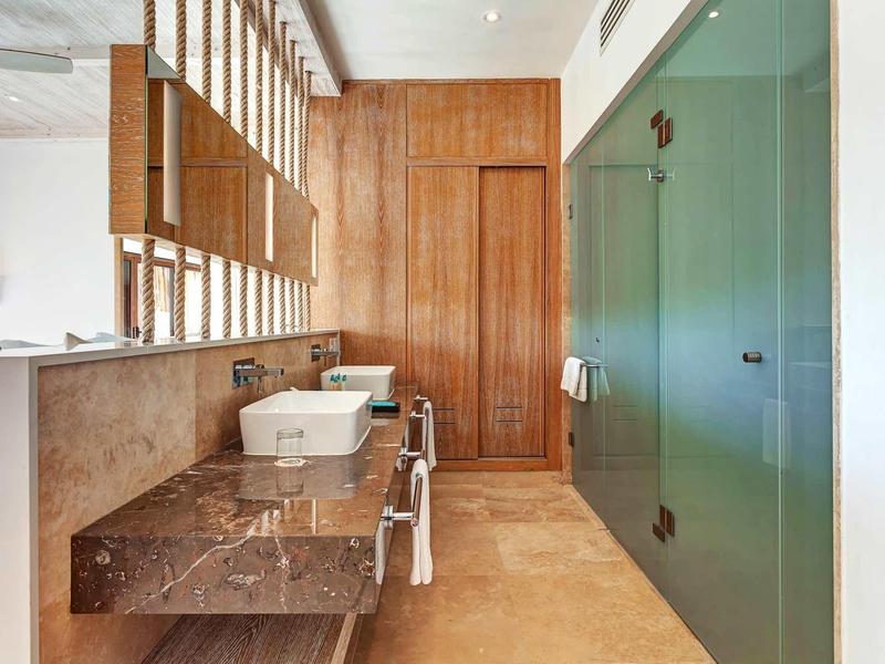 Moderner Flur mit braunem Marmorboden, grün lackierten Schränken und Holzverkleidung an der Wand.