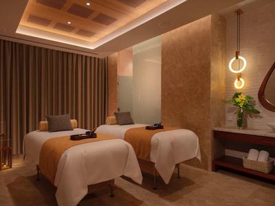 Double massage room with dim lighting and cozy atmosphere in a spa.