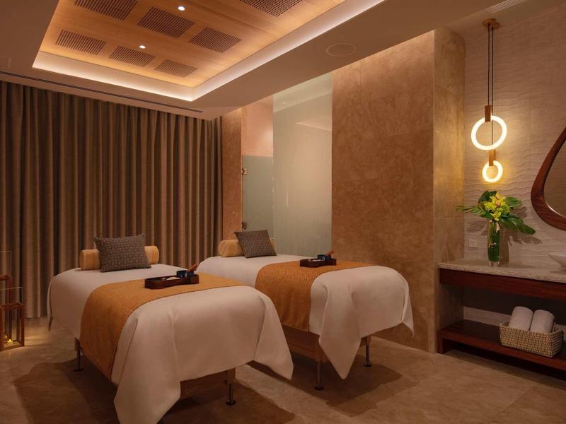 Double massage room with dim lighting and cozy atmosphere in a spa.