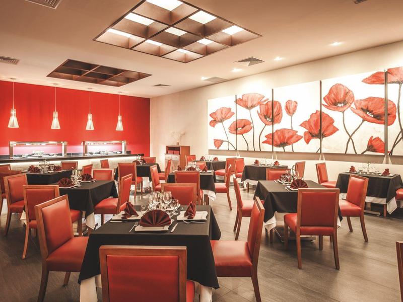 Restaurant moderne avec chaises rouges et art mural de coquelicots.