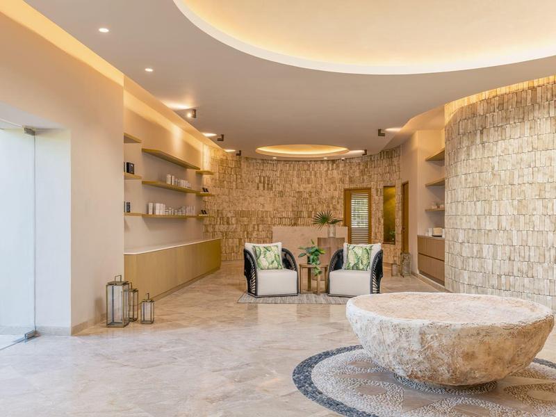 Moderne Lobby mit Runddecke, hellen Steinwänden, poliertem Boden und runder Sitzbank in der Mitte.