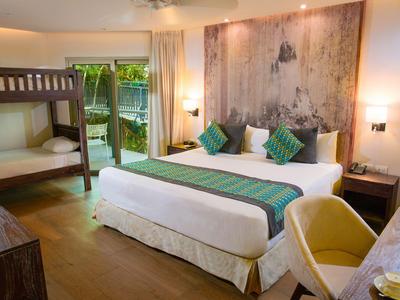 Habitación de hotel acogedora con cama doble, litera y acceso al jardín